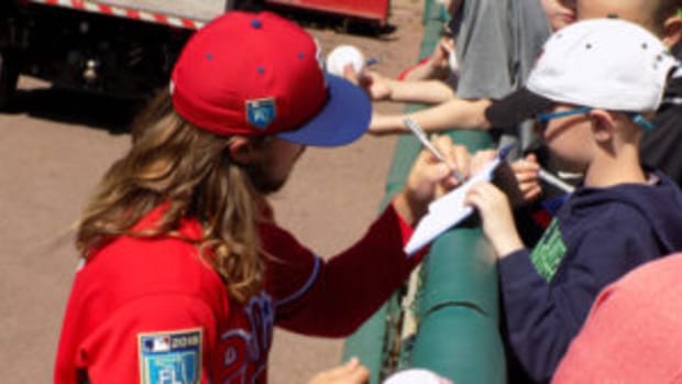  A Philadelphia Phillies player signs an autograph for a young fan at a Spring Training game. Players usually sign autographs along the fences near the dugout. (Barry Blair photos)