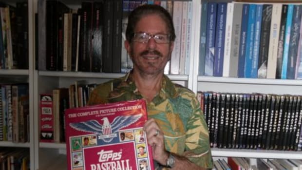 Len Brown holding the book Topps Baseball Cards. 
