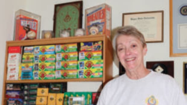  Lea Stoffer-Tatum holds up a T206 Frank Chance card in front of a small portion of her late-husband's sports cards collection. (Photo courtesy Lea Stoffer-Tatum)