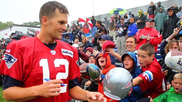 Tom Brady signs autographs at Patriots training camp in 2013.