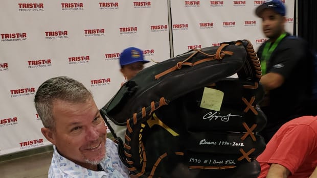Chipper Jones shows off a giant baseball glove he signed at the 2021 National.
