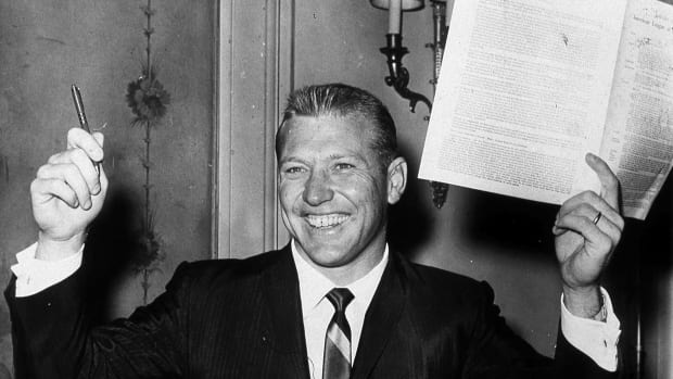 Mickey Mantle poses with his new Yankees team contract in 1961.