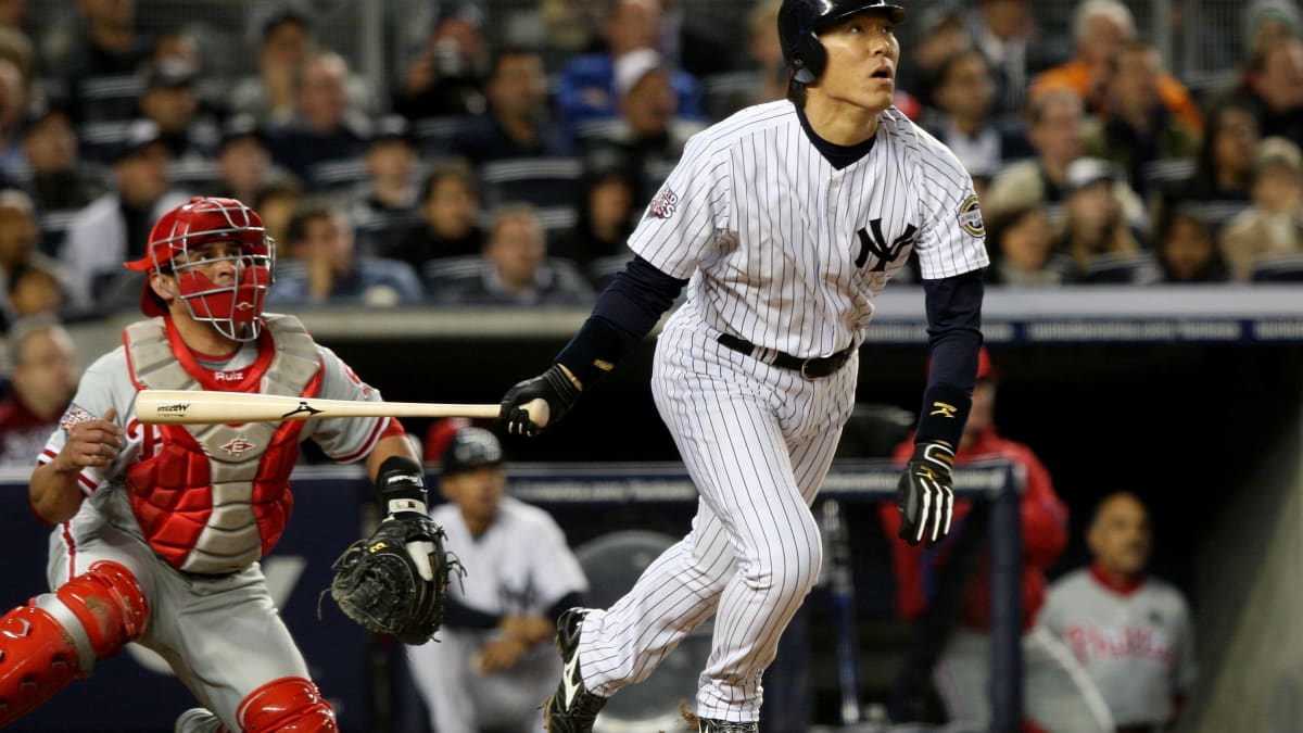 A fan of former New York Yankees outfielder and designated hitter Hideki  Matsui wears a jersey bearing his nickname Godzilla while taking  photographs of batting practice at Yankee stadium before a baseball