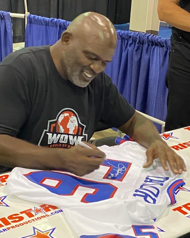 Lawrence Taylor signs a jersey at the 2021 National in Chicago.