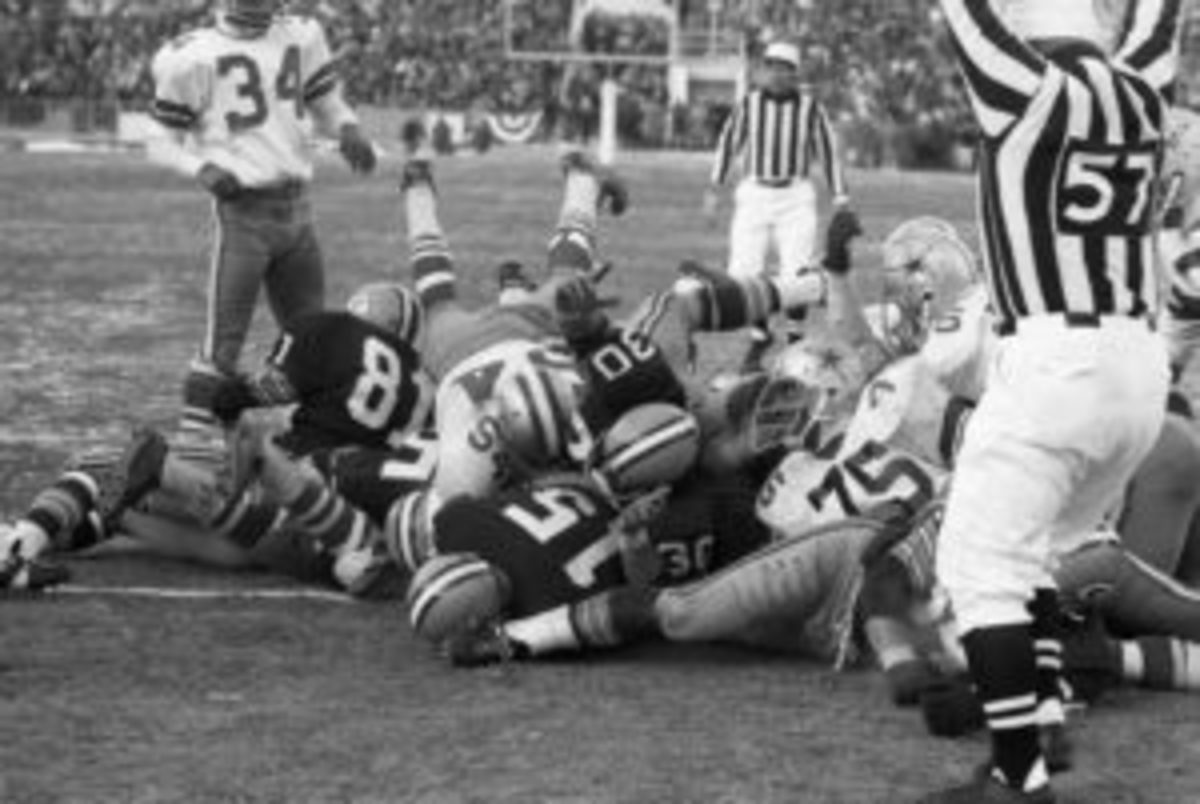  An official signals touchdown as Green Bay Packers quarterback Bart Starr (No. 15) plunges into the end zone for the winning TD in the 4th quarter of the NFL Championship game against the Dallas Cowboys on Dec. 31, 1967. (Bettmann / Contributor-GETTY IMAGES)