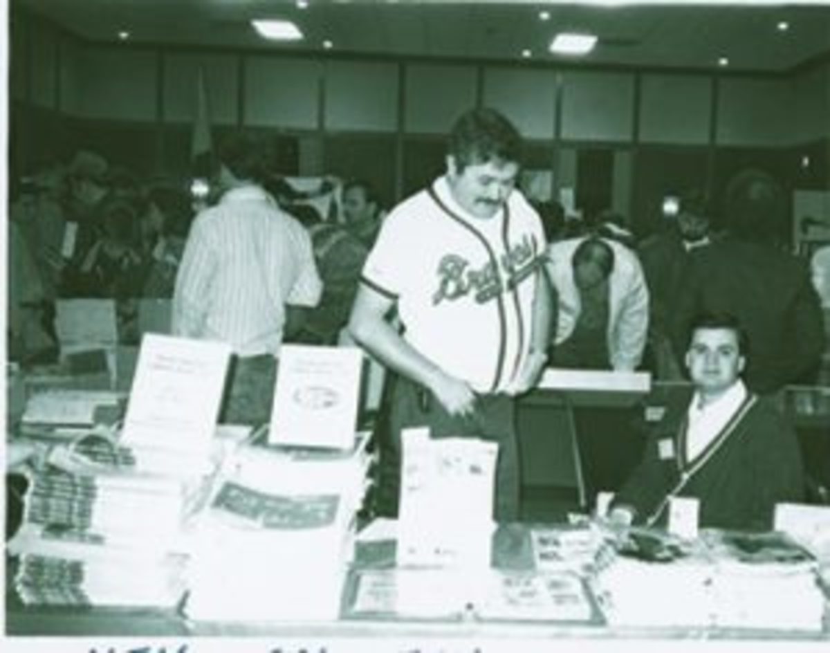 Bob Lemke (standing, wearing a Braves jersey) was an early pioneer in the sports cards hobby. Helping to advance the hobby, Lemke attended many card shows to get Sports Collectors Digest and Baseball Cards magazine into the hands of collectors.