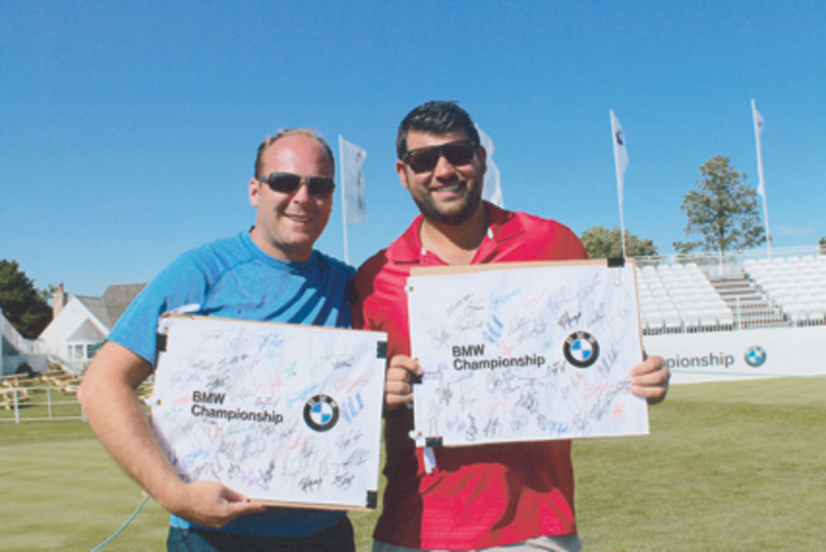 Local collectors Barry Glas and Bradley Factor show off their signed flags at the putting green. 