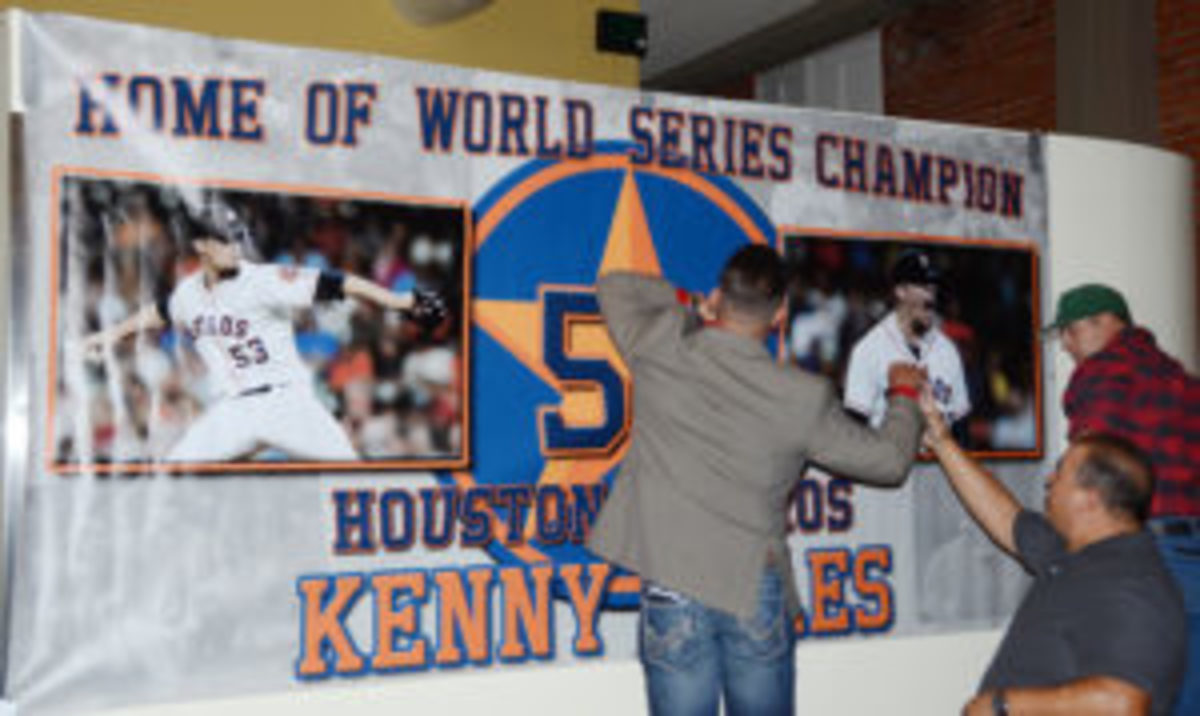  Rio Grande High baseball coach Orlando Griego, at right, helps hang a sign before the recent fundraising banquet.