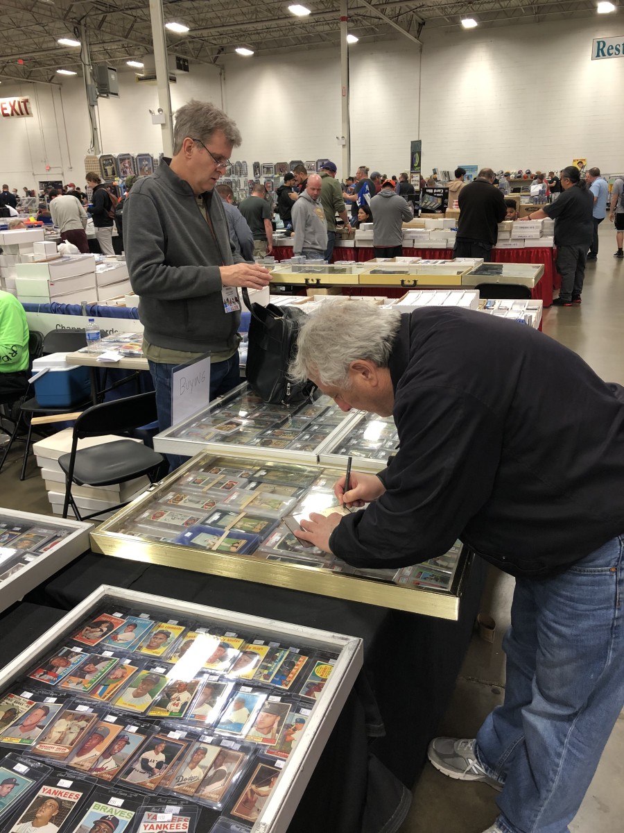 Dealer Bill Chappell helps a collector at the spring Chantilly Show.