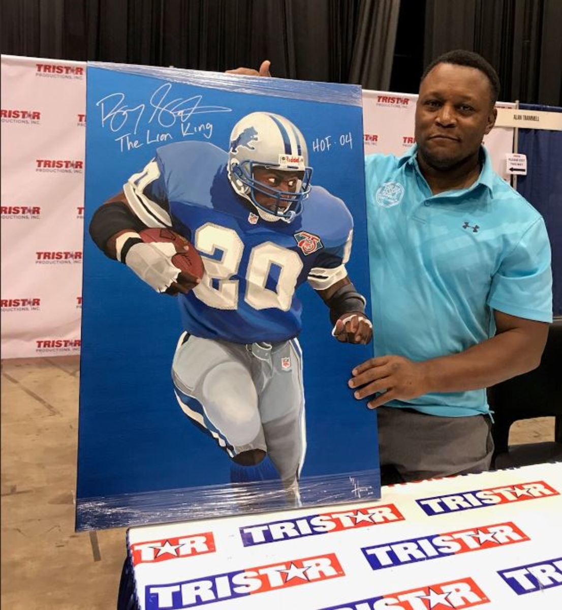 Hall of Famer Barry Sanders shows off a signed poster at the 2019 National.