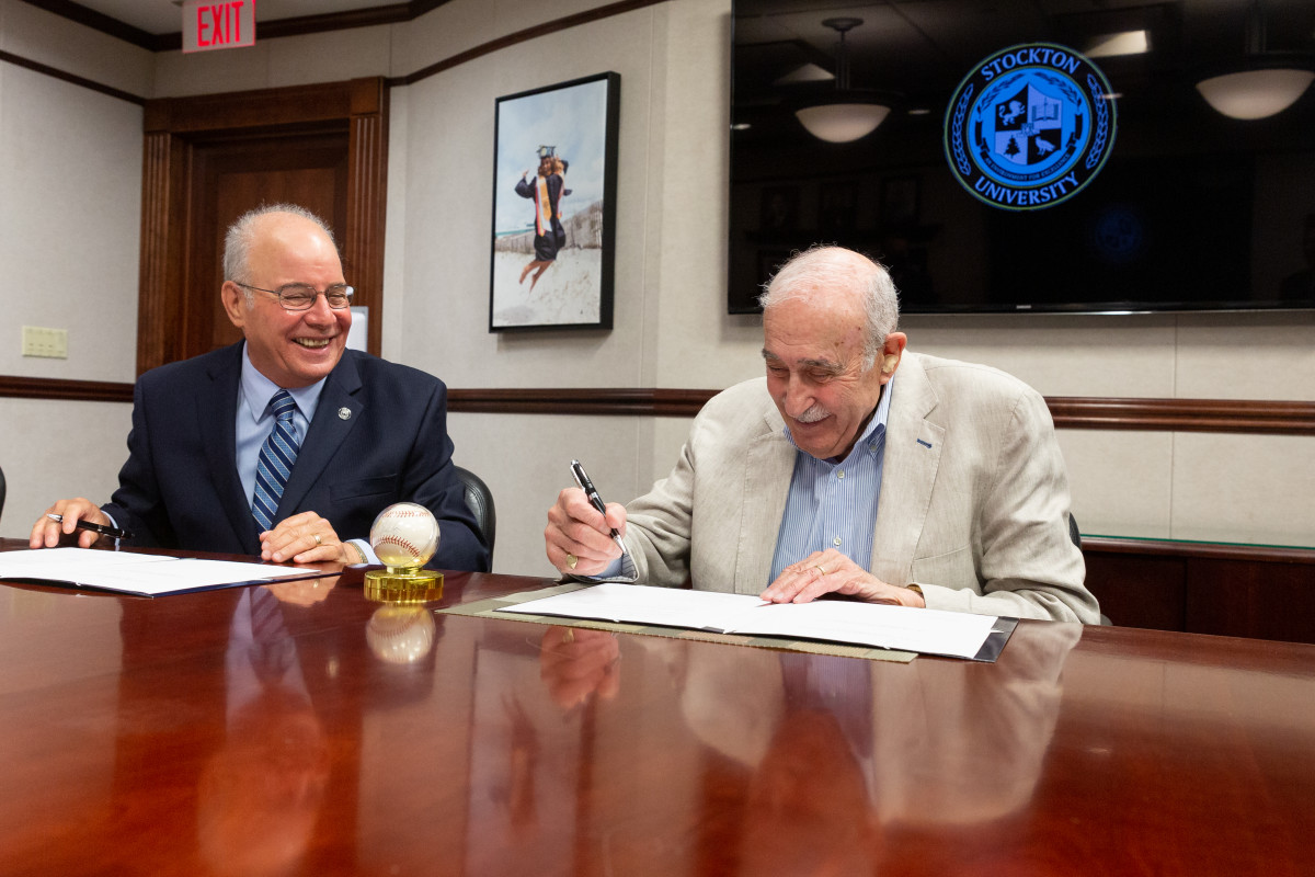 Stockton President Harvey Kesselman and Leo S. Ullman (right) sign an agreement to donate Ullman's Nolan Ryan collection to the university.
