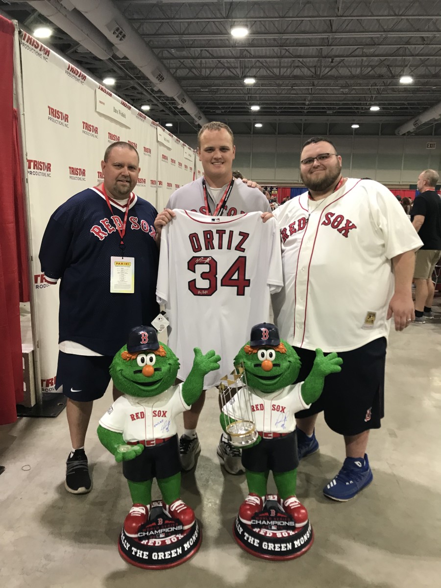 Red Sox fan Tom Brode and his sons pose with a jersey and bobbleheads they got signed by David Ortiz at The National.