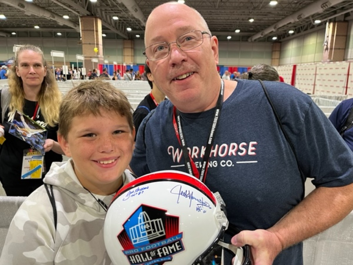 Darryl and Ryan Naegle with an NFL Hall of Fame helmet signed by Mean Joe Greene.
