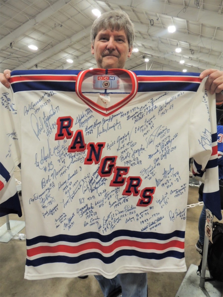 NHL fan Jerry Caron shows off his New York Rangers jersey signed by former players.