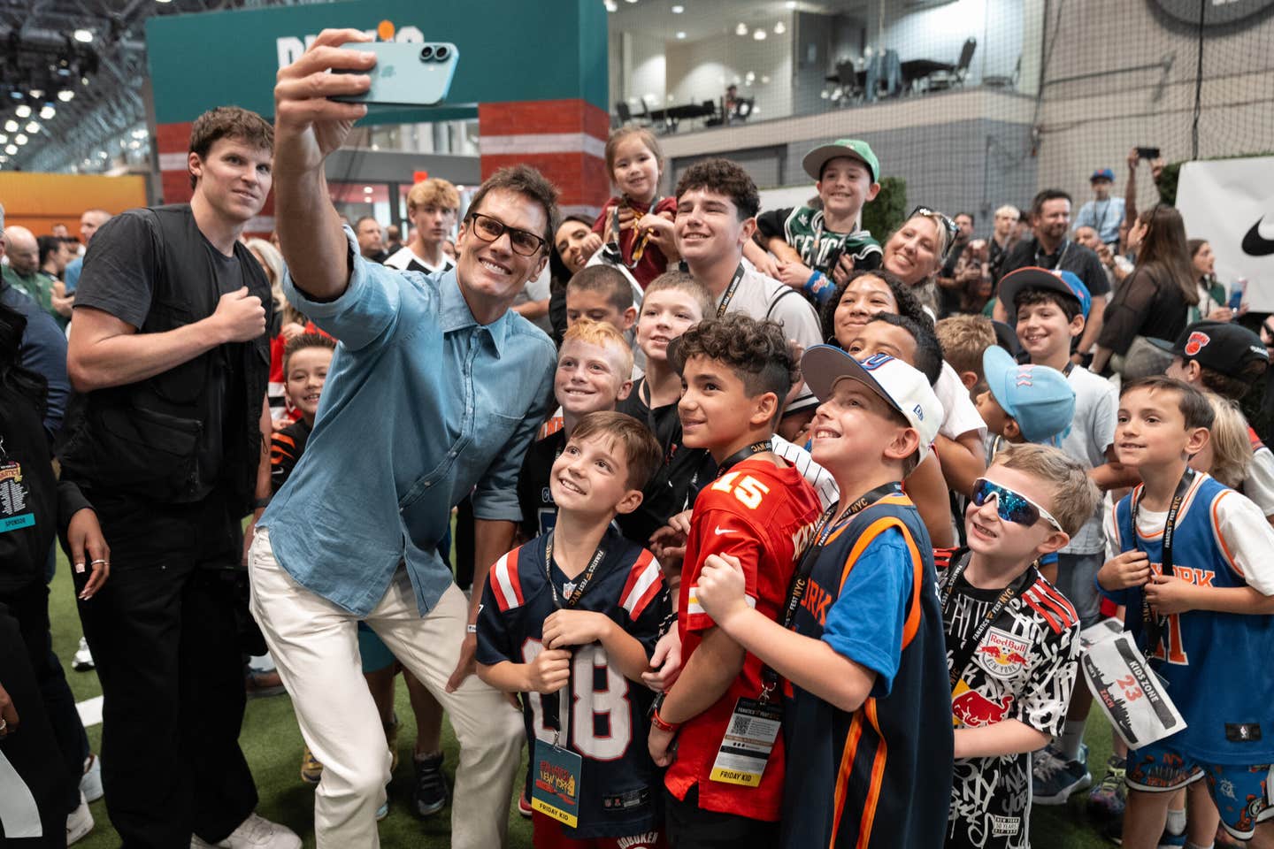 Tom Brady is surrounded by kids at Fanatics Fest NYC.