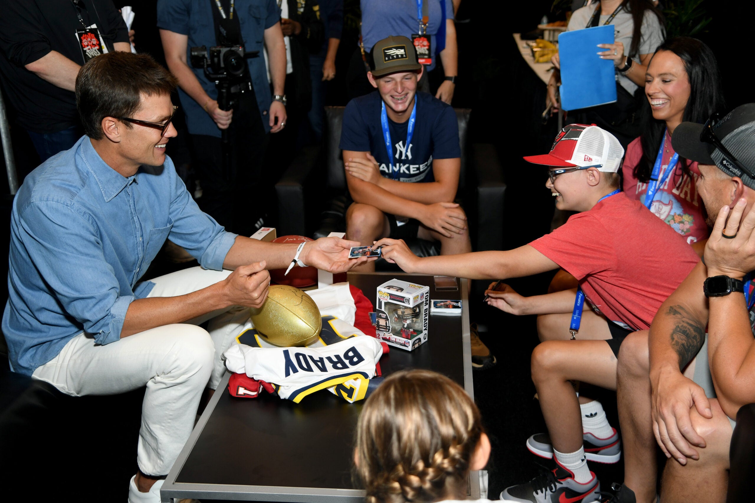 Tom Brady shares a trading card with Make-A-Wish kid Axton Robertson. 