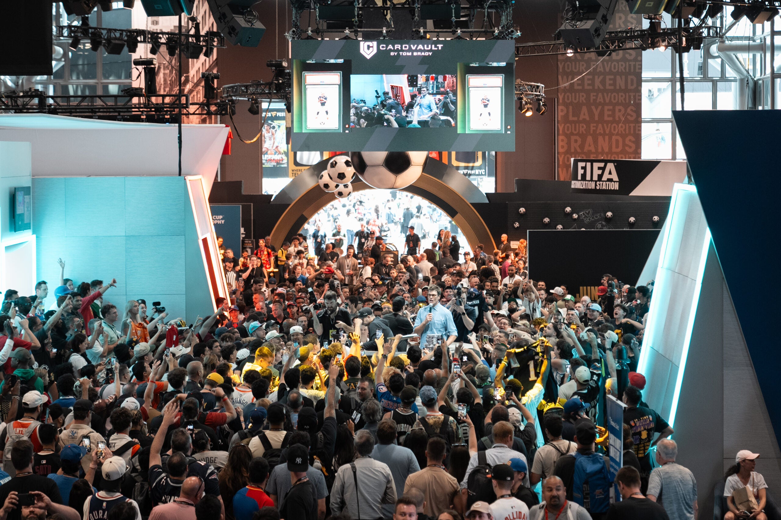 A big crowd of fans and collectors surround Tom Brady on the show floor at Fanatics Fest NYC. 