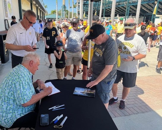 Former Rockies and Pirates manager Clint Hurdle signs autographs at Pirates Spring Training. 