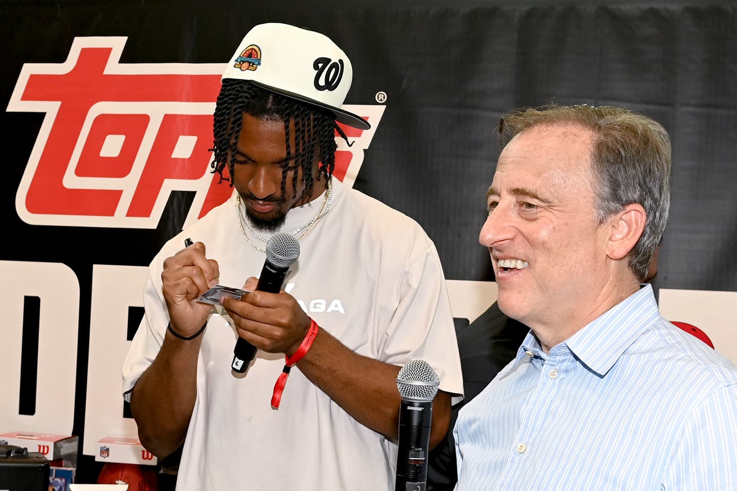 Jayden Daniels signs a trading card with Washington Commanders team owner Josh Harris at Fanatics Fest NYC.