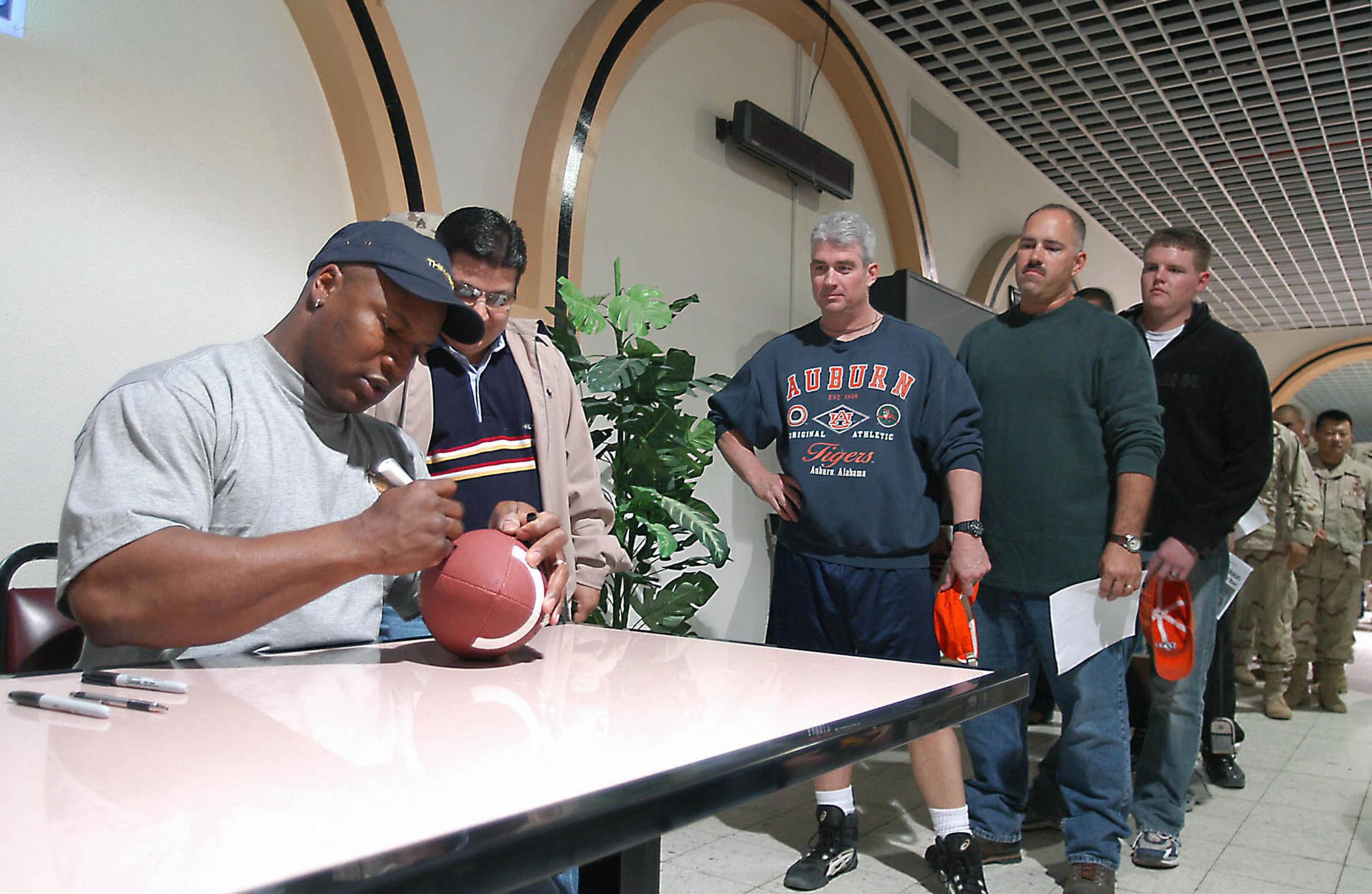 Bo Jackson signs autographs during a visit with U.S. troops at Camp Doha in Kuwait City during Super bowl weekend in January 2004.