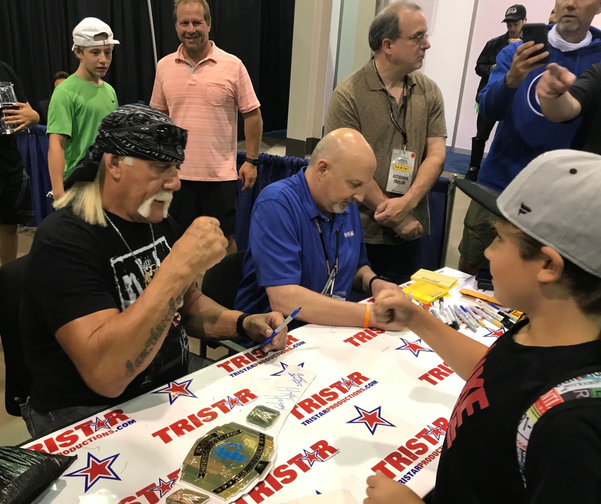 Hulk Hogan gives a fist-bump to a young fan at the National Sports Collectors Convention in 2021. 
