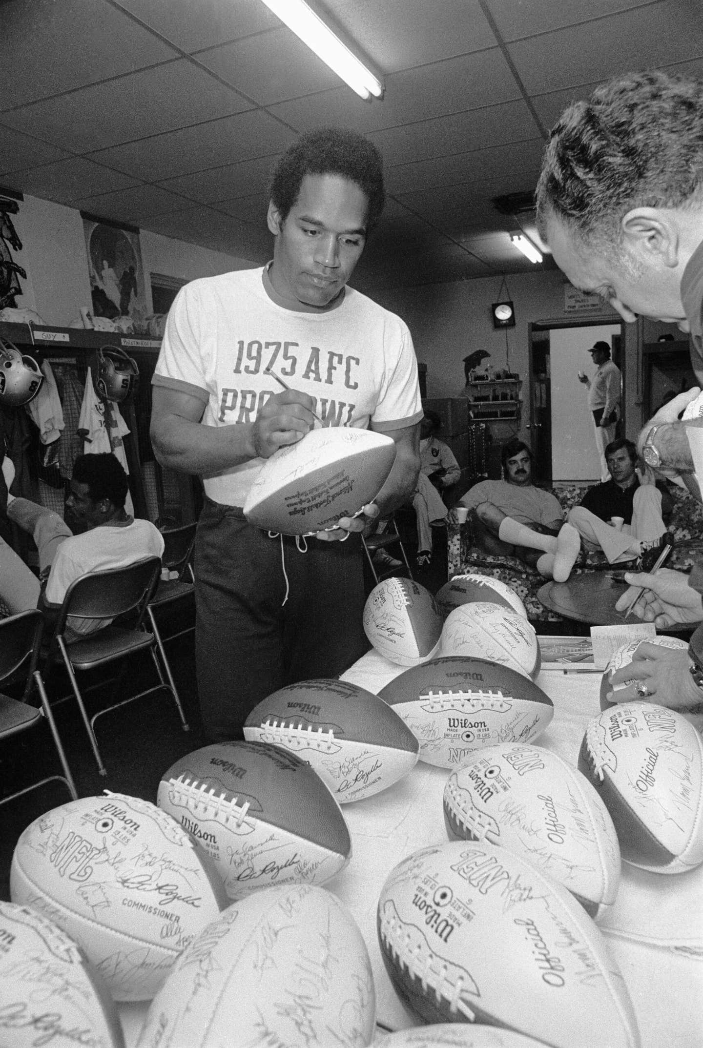 O.J. Simpson signs footballs in 1975.