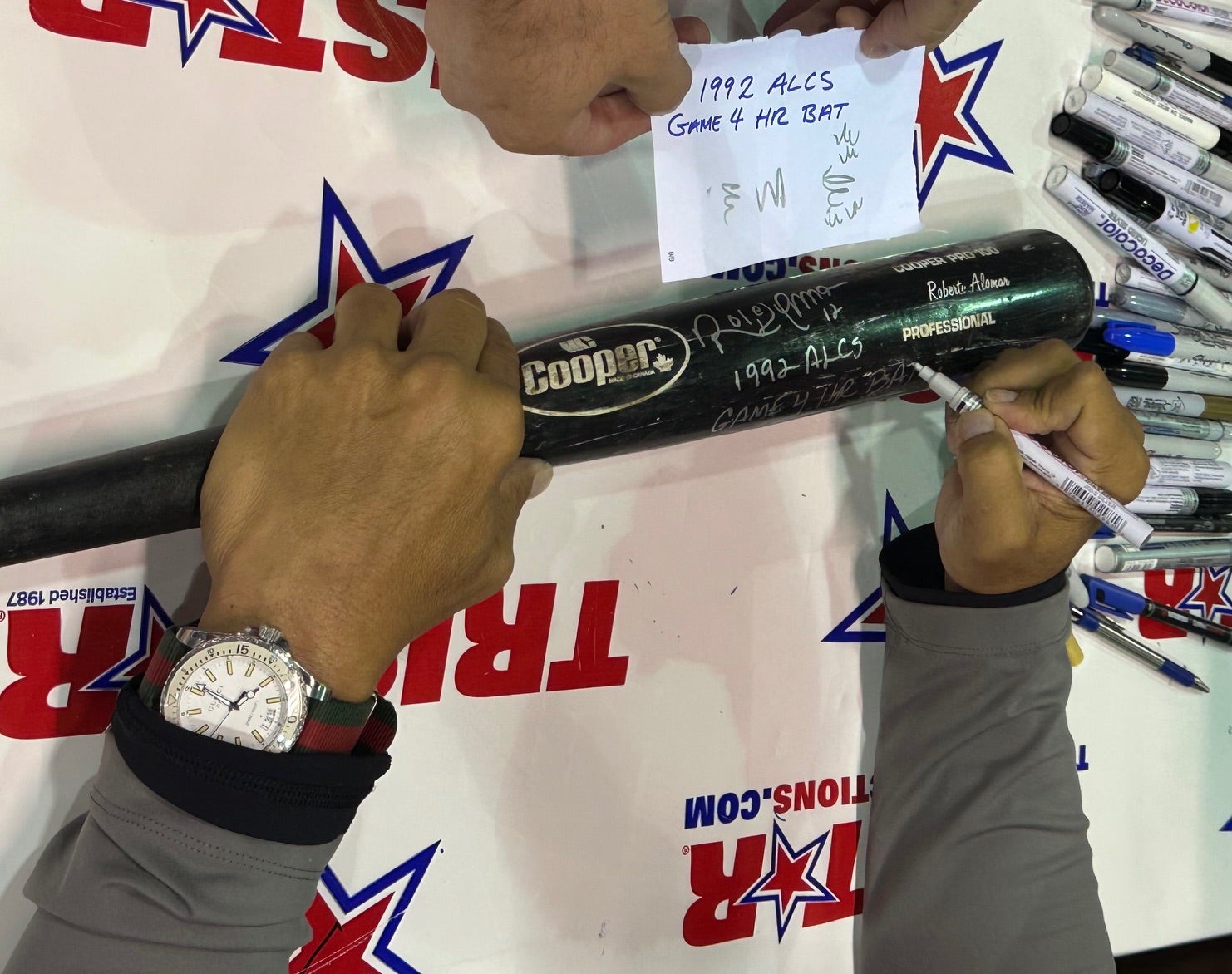 Roberto Alomar signs the bat he used to hit a clutch home run for the Toronto Blue Jays in the 1992 ALCS. 