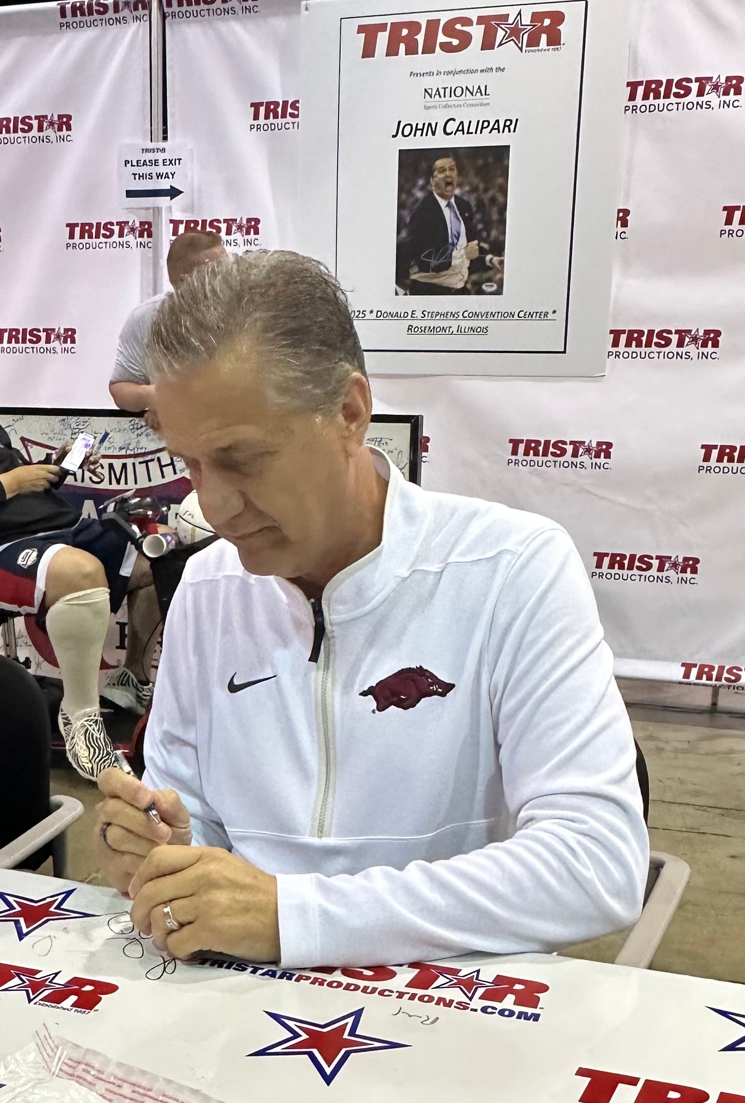 Basketball coaching legend John Calipari signs a baseball at The National. 