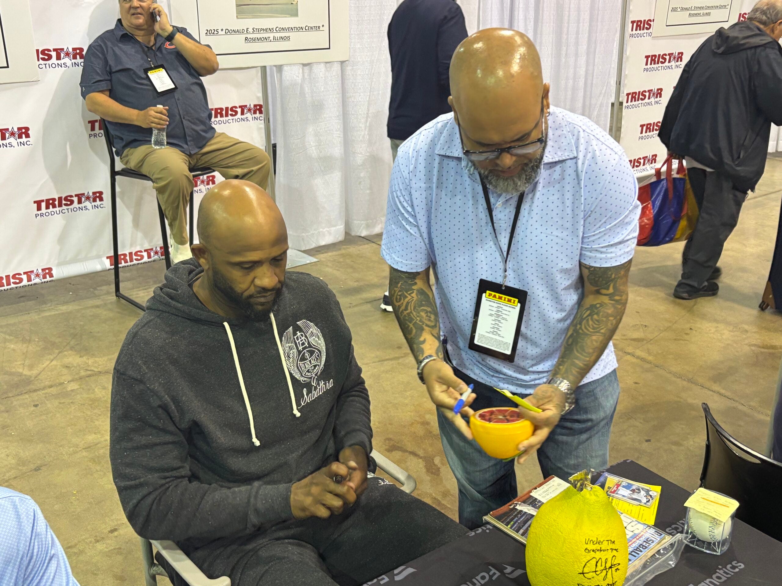 Former New York Yankees ace and new Baseball Hall of Famer CC Sabathia signs a ceramic orange at the 2025 NSCC in Chicago. 