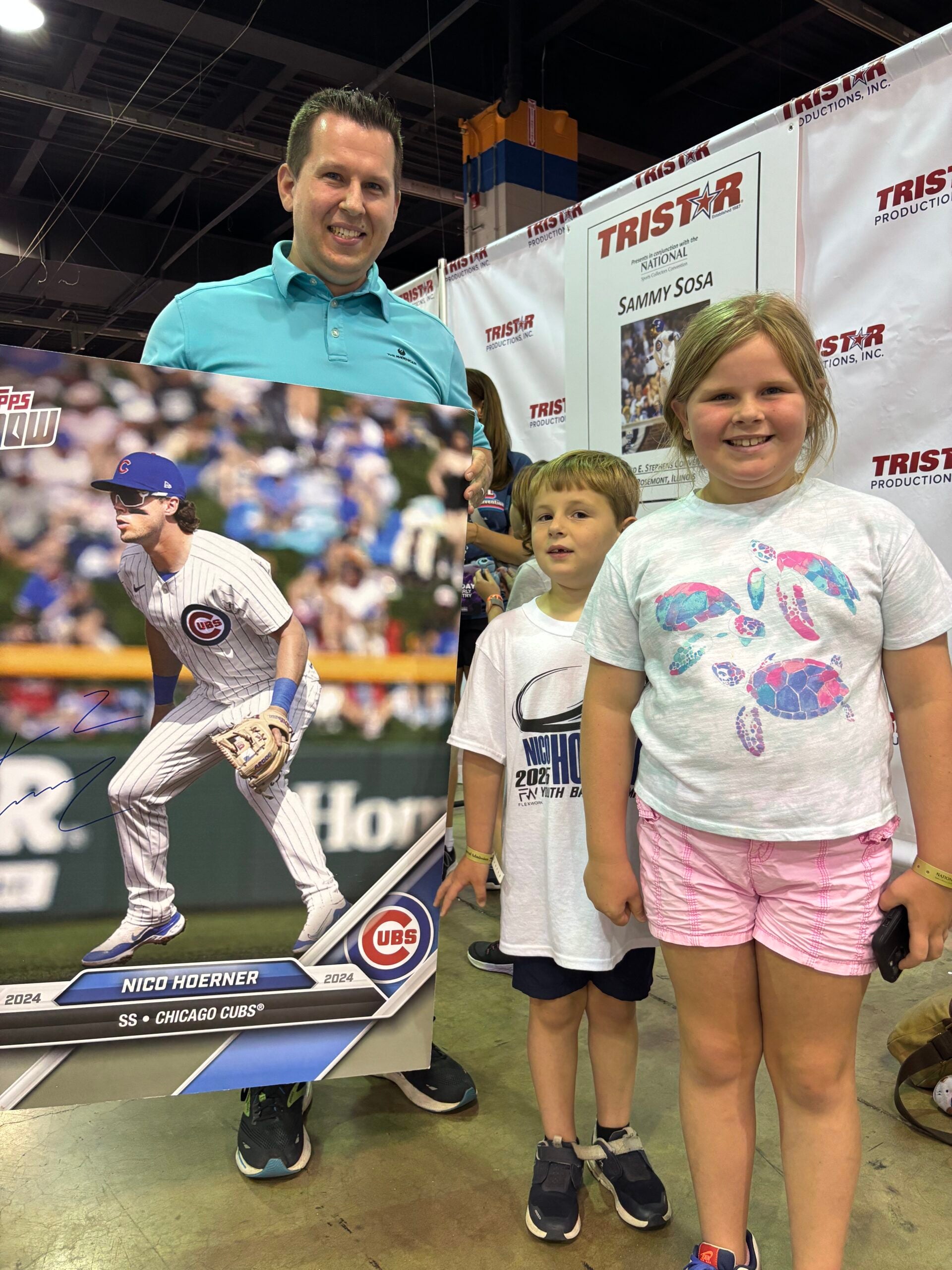 Ryan Mroz, with his son Jack and daughter Madison, show off their signed giant baseball card of Chicago Cubs infielder Nico Hoerner. 
