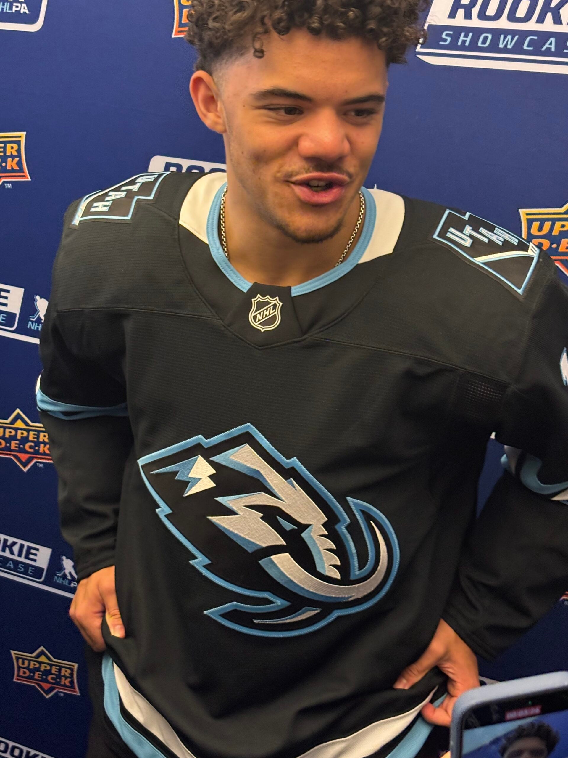NHL rookie Tij Iginla shows off the Utah Mammoth’s new logo and jersey at the 2025 Upper Deck NHLPA Rookie Showcase. 