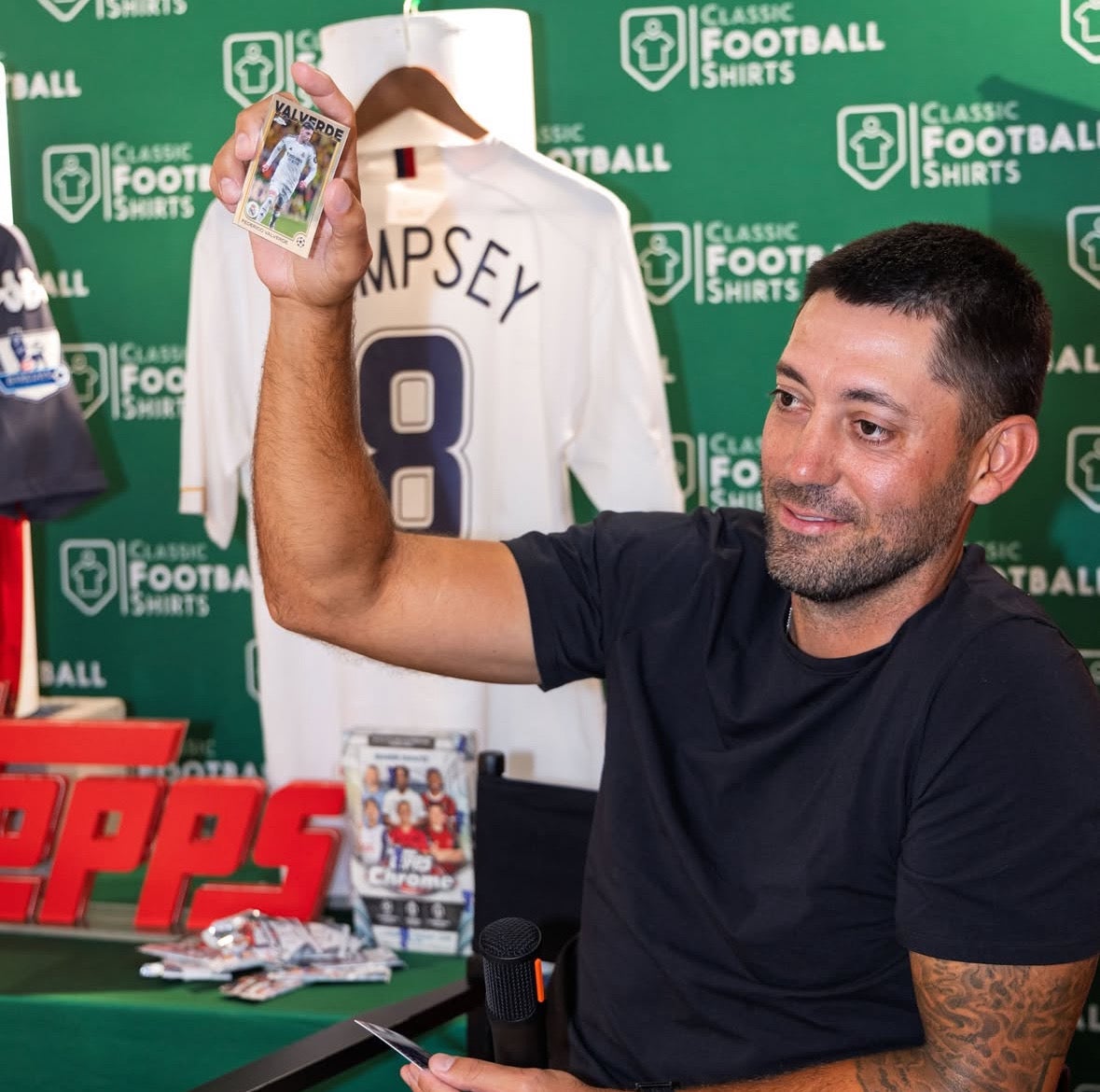 Former U.S. soccer star Clint Dempsey rips a pack of cards during a launch party for Topps Chrome UEFA Club Competitions in New York City. 