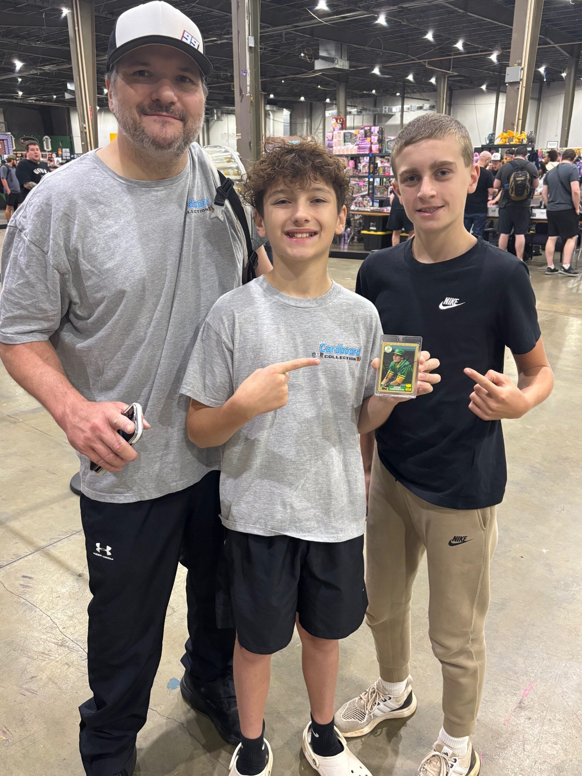 Chris Rhinehart and his sons Bryce and Riker with a Jose Canseco card at the Charlotte Card Show. 
