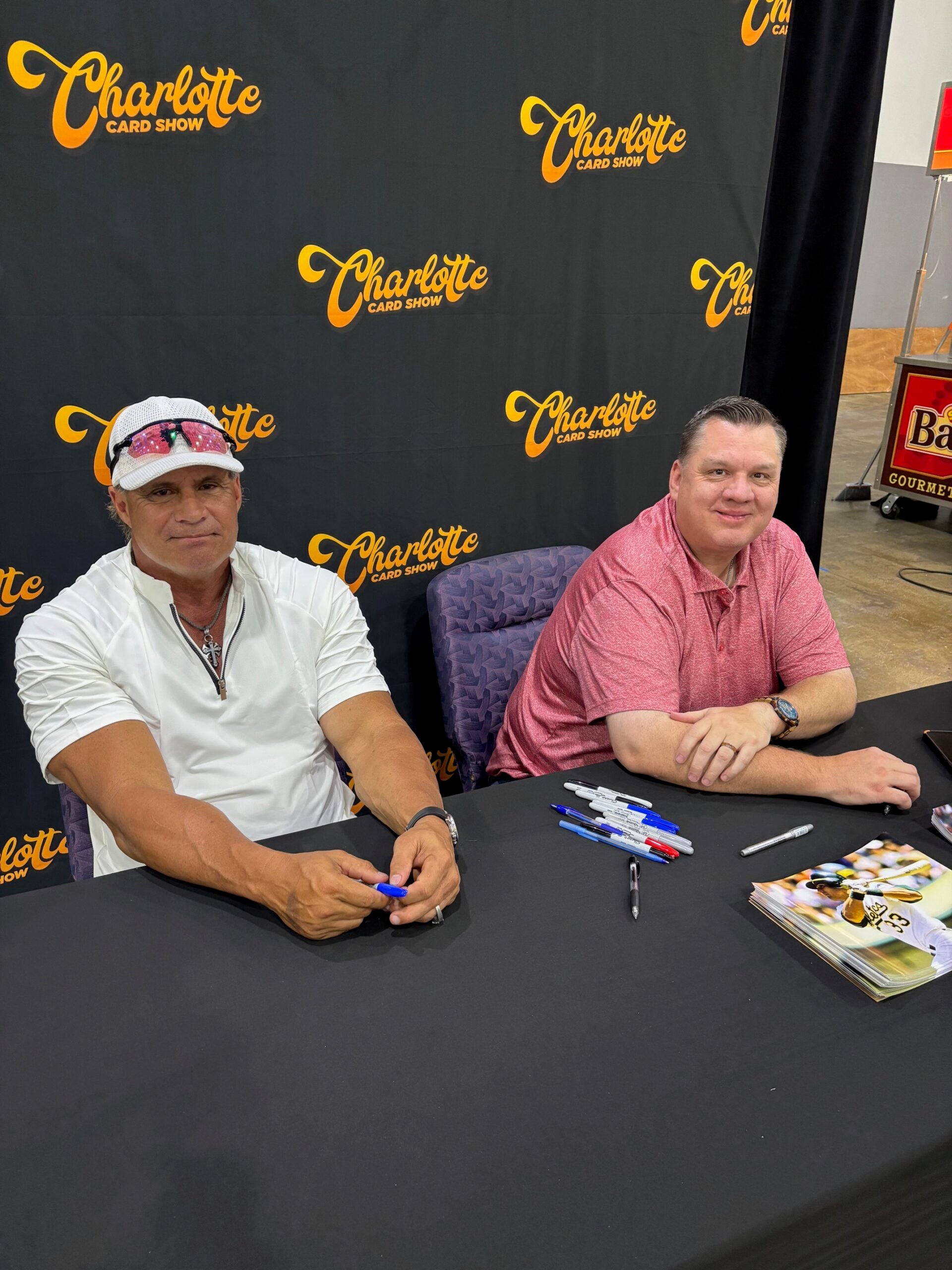 Jose Canseco signs autographs with his agent, Mike Maguire, at the Charlotte Card Show. 