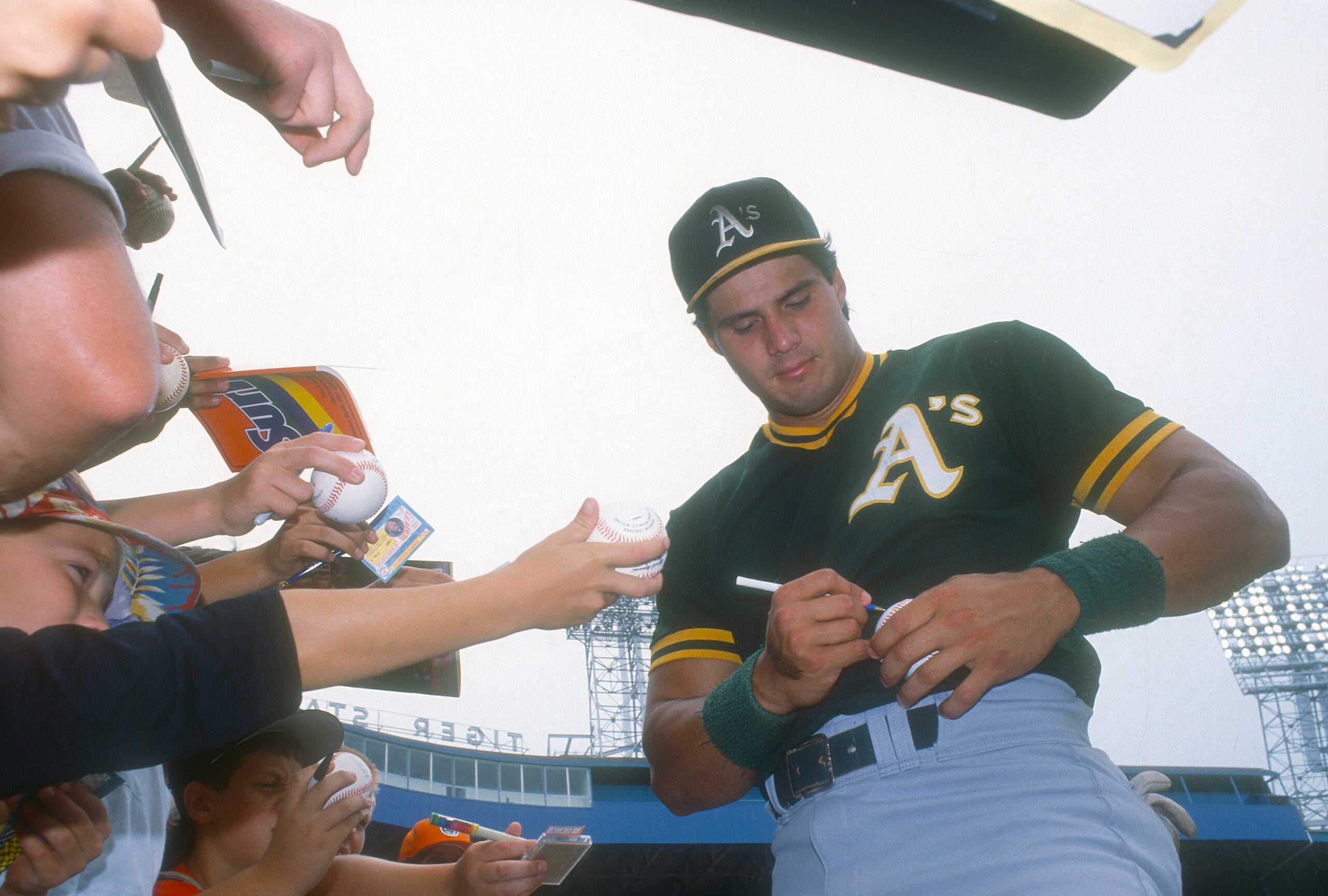 Jose Canseco signs autographs for fans at Tiger Stadium in Detroit circa 1990. 