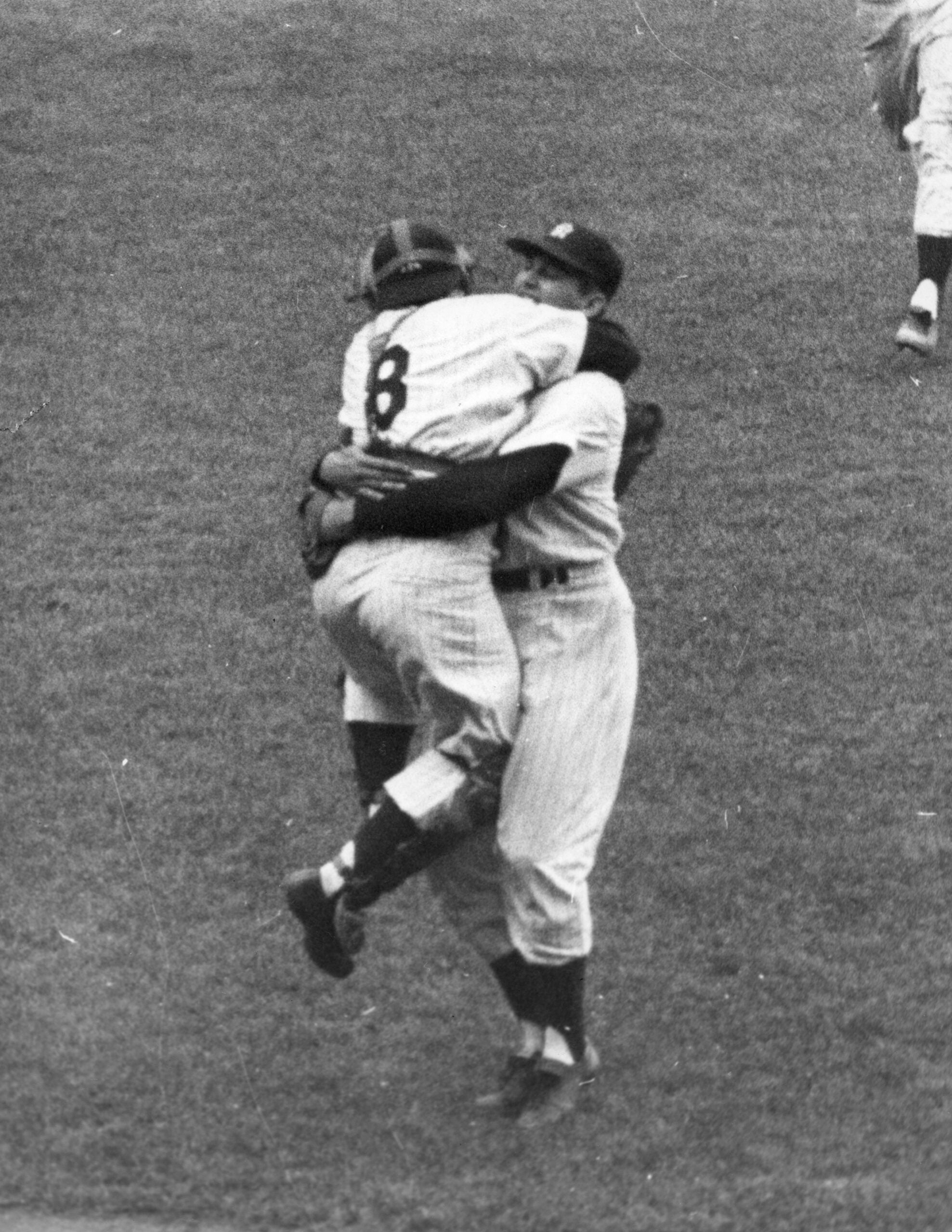 Yankee catcher Yogi Berra jumps up and down as he hugs teammate Don Larsen following Larsen pitching the first perfect game in World Series history. 